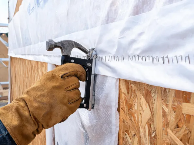 Stapler fastening house wrap